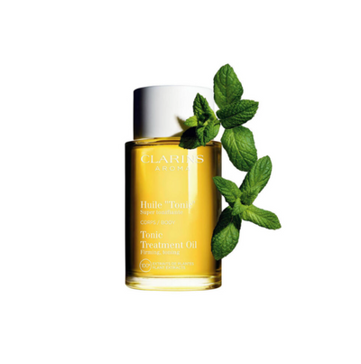 Clarins Tonic Treatment Oil with mint leaves on a white background